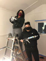 Volunteers caulking the inside of a tiny home
