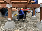 Volunteer helping to level and set decking at Progressive Skyway Tiny House Village