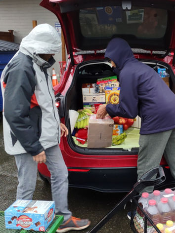 Generous donors from Microsoft unloading food at Miracle Temple Tiny House Village