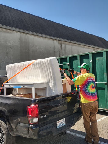 LIHI staff loading up a mattress and furniture to deliver to a client